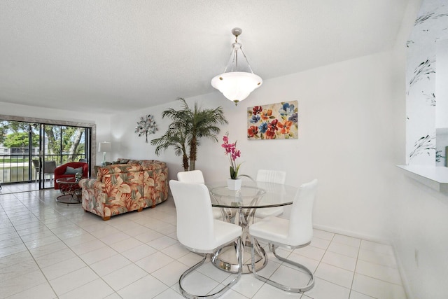 dining area featuring a textured ceiling and light tile patterned flooring