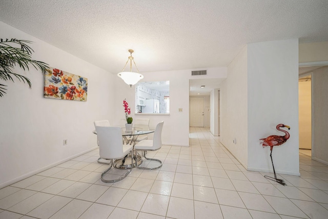 tiled dining area with a textured ceiling