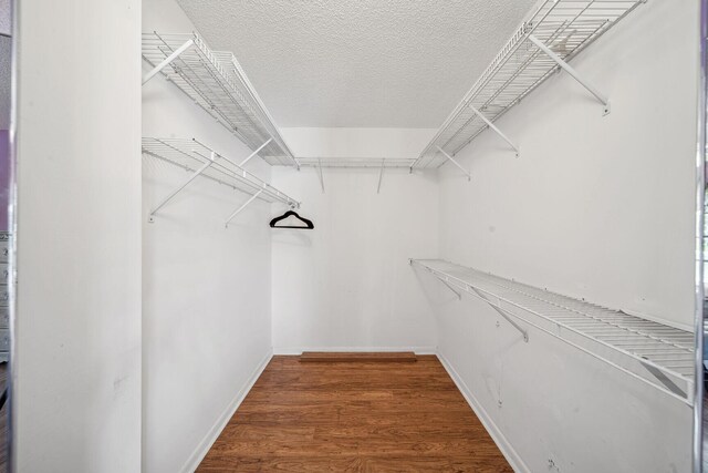 bedroom with ceiling fan, a textured ceiling, and hardwood / wood-style flooring