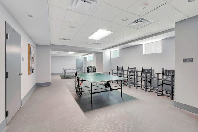 game room featuring a paneled ceiling and light colored carpet