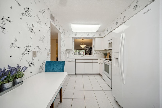 kitchen featuring white cabinets, sink, white appliances, and a textured ceiling