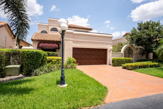 mediterranean / spanish home featuring a front lawn and a garage