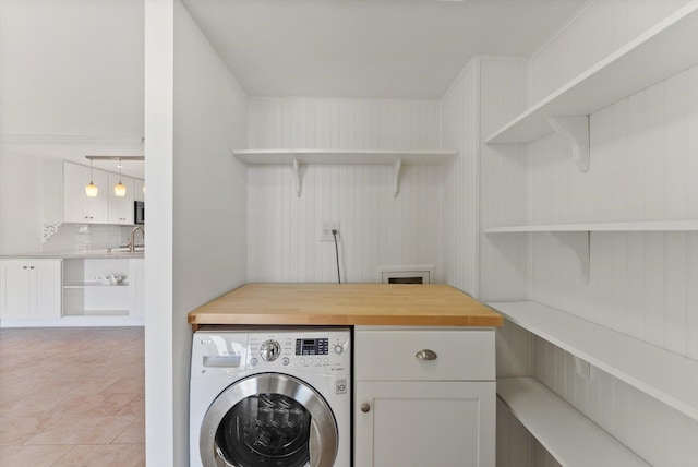 laundry room with cabinets, sink, washer / dryer, and light tile floors