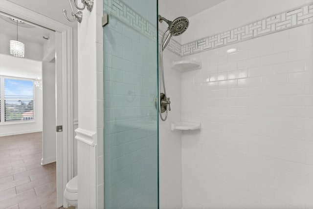 bathroom featuring a tile shower, tile flooring, and toilet