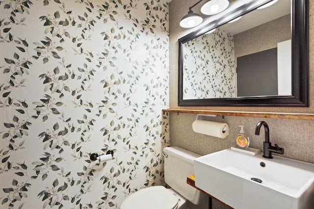 bathroom with toilet, sink, and tasteful backsplash