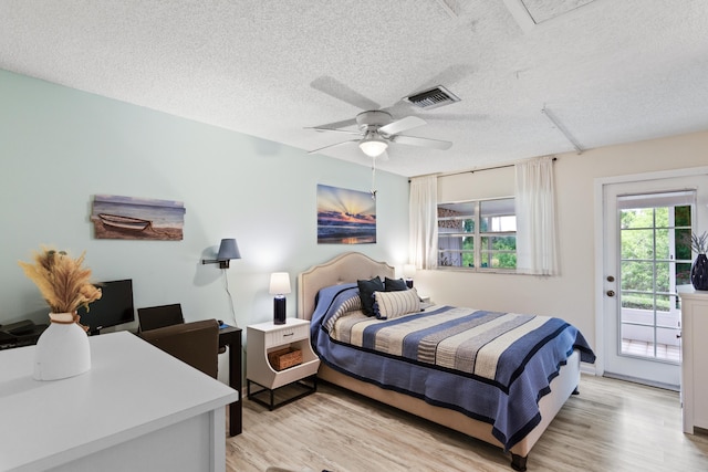 bedroom with ceiling fan, a textured ceiling, light hardwood / wood-style flooring, and access to outside