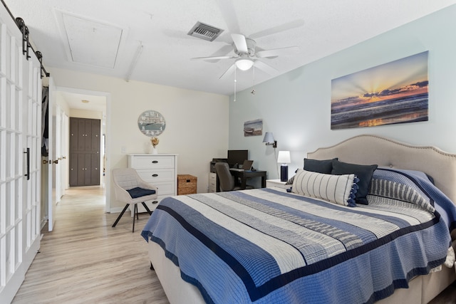 bedroom featuring light wood-type flooring, ceiling fan, and a textured ceiling