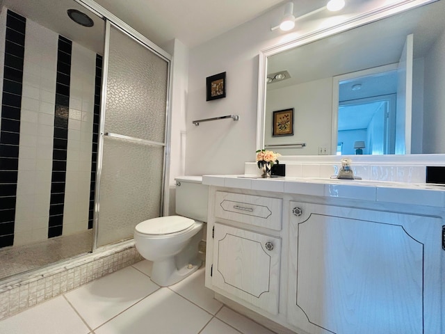 bathroom featuring a shower with door, toilet, tile floors, and large vanity