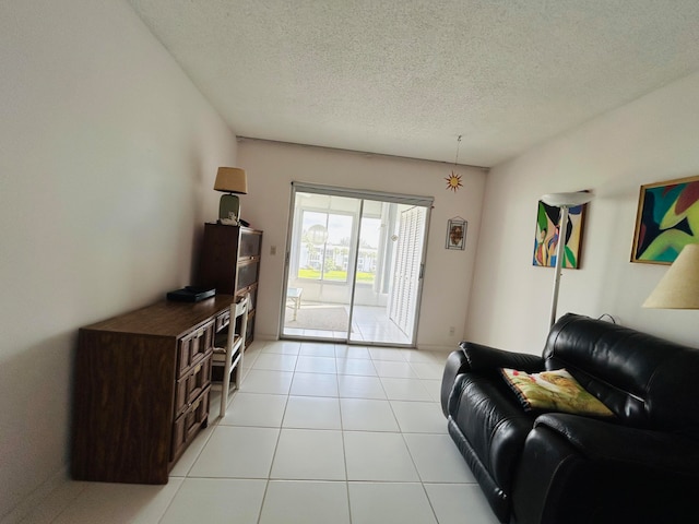 tiled living room featuring a textured ceiling