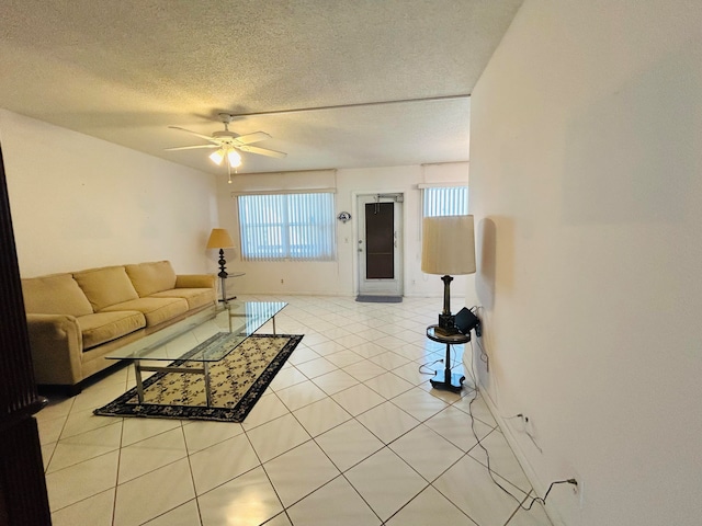 living room featuring a textured ceiling, light tile flooring, and ceiling fan