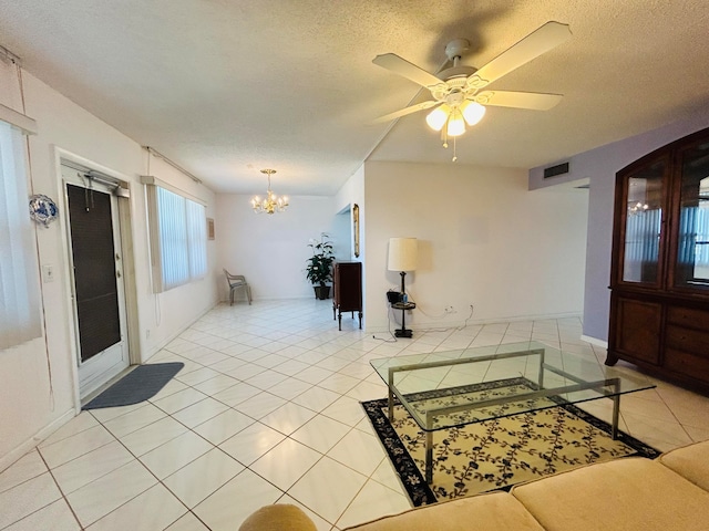 tiled living room with a textured ceiling and ceiling fan with notable chandelier