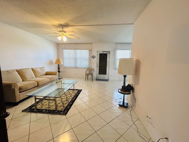 living room with a wealth of natural light, a textured ceiling, ceiling fan, and light tile floors