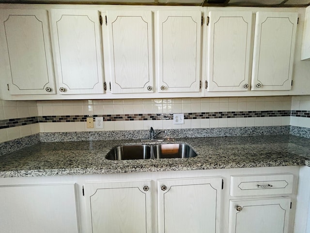 kitchen featuring sink, white cabinets, and tasteful backsplash