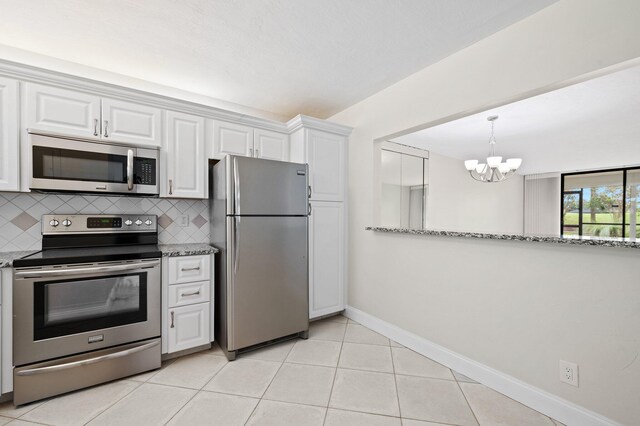 kitchen featuring dishwasher, sink, decorative backsplash, dark stone countertops, and light tile patterned floors