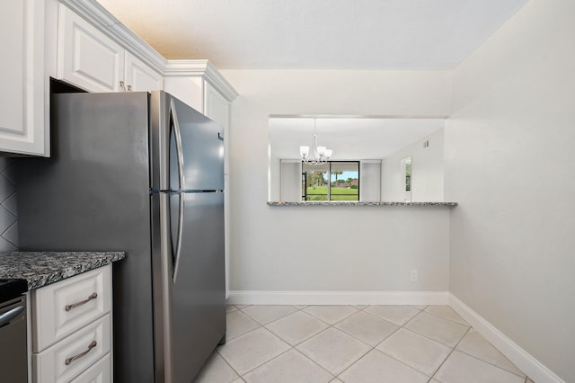 kitchen featuring light tile patterned floors, dark stone counters, white cabinetry, and stainless steel refrigerator