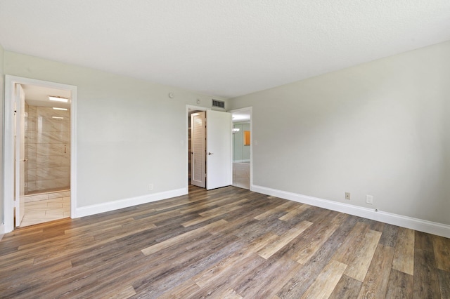 empty room featuring a textured ceiling and dark wood-type flooring