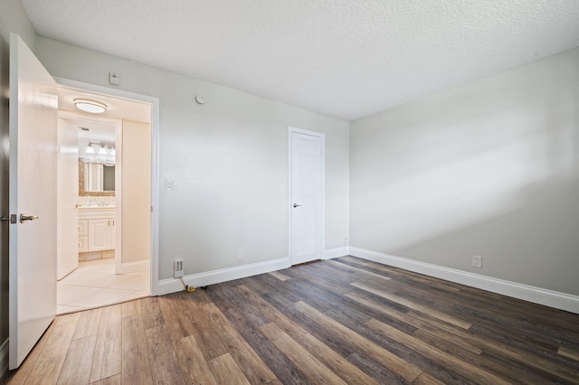 spare room with a textured ceiling and dark wood-type flooring