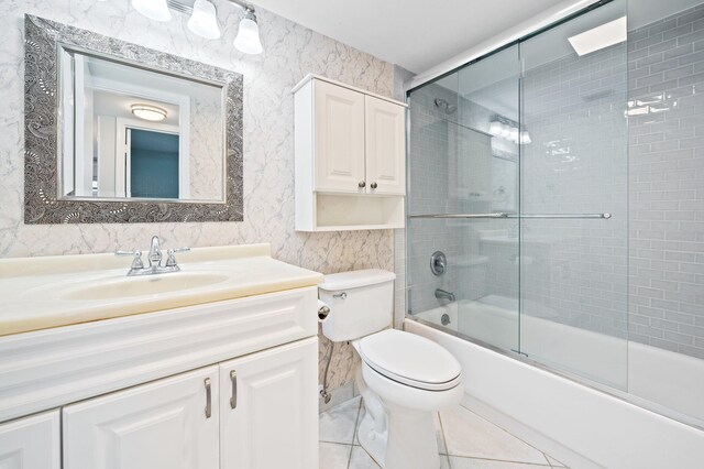 full bathroom with toilet, vanity, and bath / shower combo with glass door