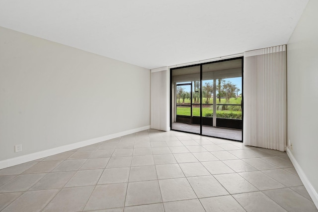 unfurnished room featuring floor to ceiling windows and light tile patterned floors