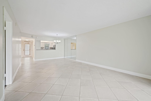 tiled empty room featuring a chandelier