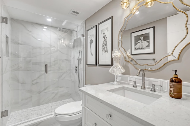 bathroom with vanity, toilet, and a shower with door