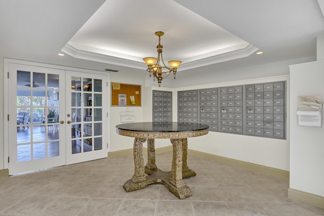 dining space with mail boxes, a raised ceiling, crown molding, and french doors