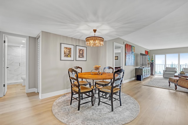 dining area featuring a notable chandelier and light hardwood / wood-style floors