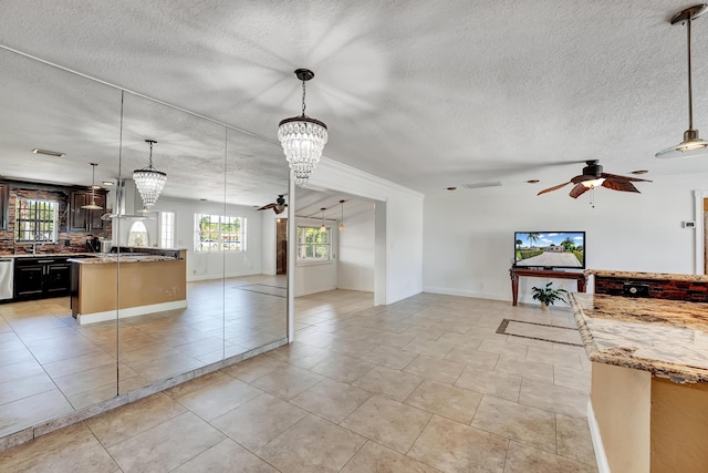 kitchen with light stone countertops, ceiling fan with notable chandelier, pendant lighting, light tile patterned floors, and dishwasher