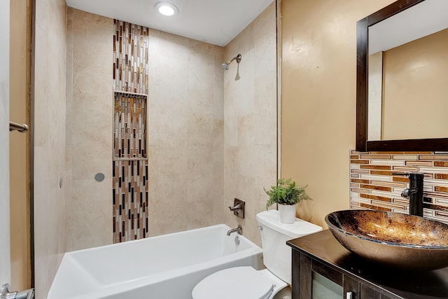 full bathroom featuring tiled shower / bath combo, toilet, vanity, and tasteful backsplash