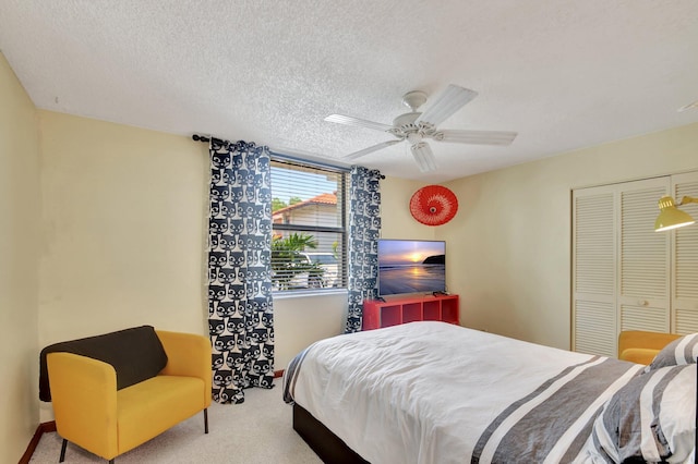 bedroom with carpet flooring, a textured ceiling, a closet, and ceiling fan