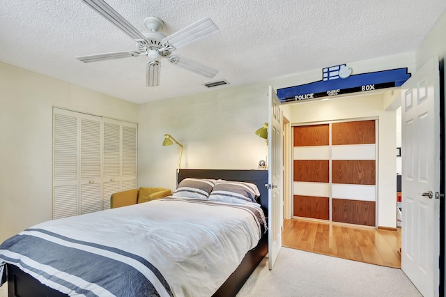 bedroom featuring ceiling fan, carpet floors, and a textured ceiling