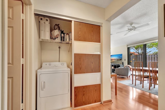 washroom featuring ceiling fan, washer / clothes dryer, a textured ceiling, wooden walls, and light wood-type flooring