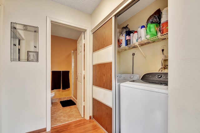 washroom featuring light hardwood / wood-style floors, a textured ceiling, and independent washer and dryer