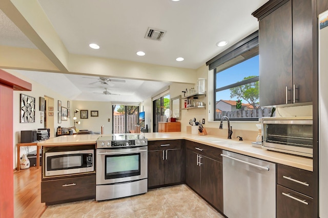 kitchen featuring plenty of natural light, kitchen peninsula, sink, and appliances with stainless steel finishes