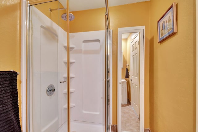 bathroom with a shower with door and tile patterned flooring