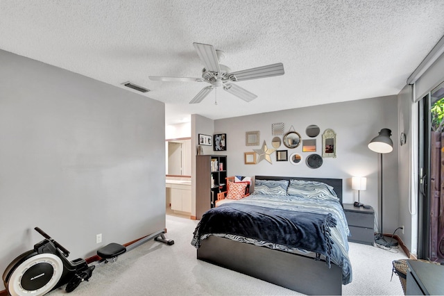 bedroom with carpet, a textured ceiling, connected bathroom, and ceiling fan