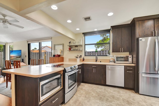 kitchen featuring kitchen peninsula, ceiling fan, sink, and stainless steel appliances