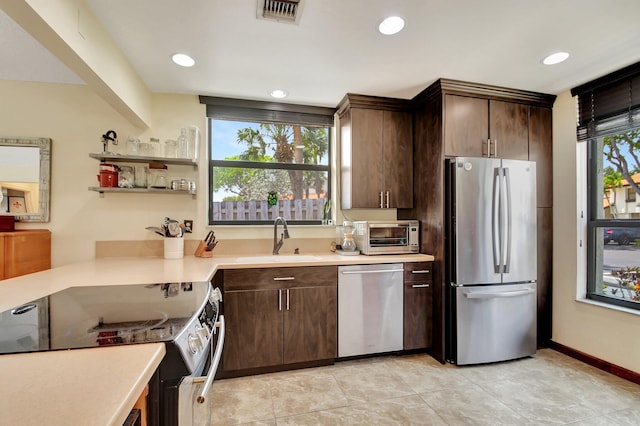 kitchen featuring sink, stainless steel appliances, and dark brown cabinets