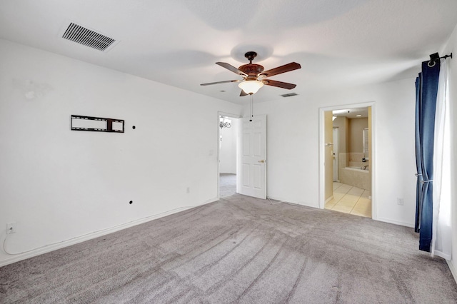 unfurnished bedroom featuring ceiling fan, connected bathroom, and light colored carpet