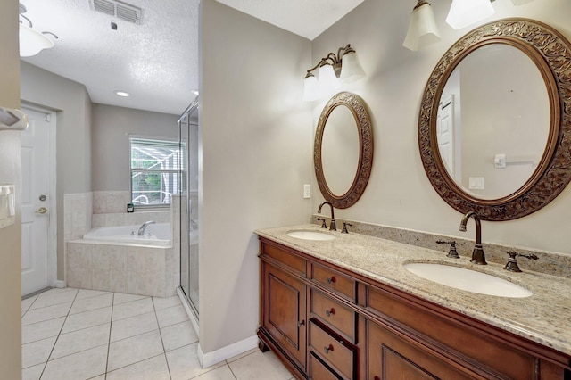 bathroom featuring tile patterned floors, shower with separate bathtub, dual bowl vanity, and a textured ceiling