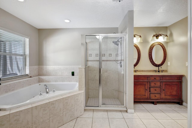 bathroom with dual vanity, shower with separate bathtub, a textured ceiling, and tile patterned floors