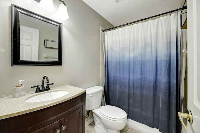 bathroom featuring tile patterned flooring, toilet, vanity, and a textured ceiling