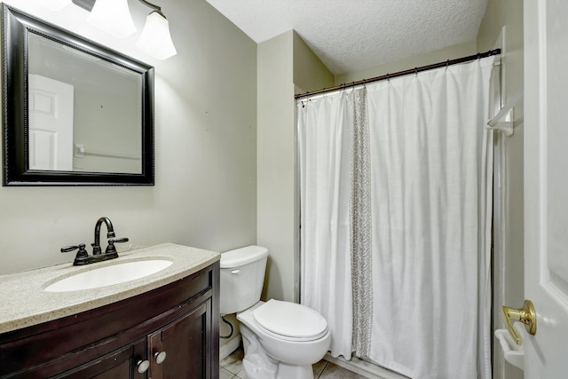 bathroom with tile patterned floors, vanity, a textured ceiling, and toilet