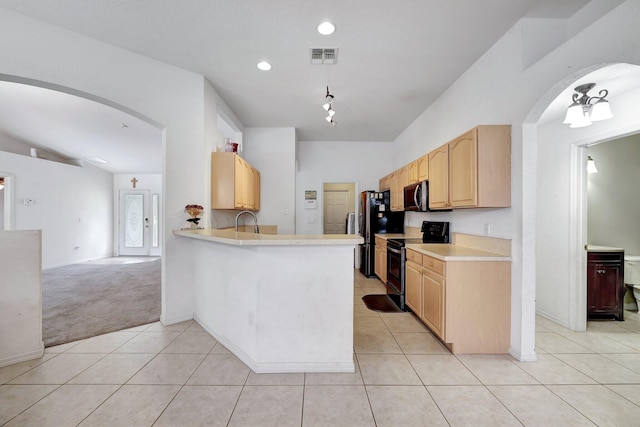 kitchen featuring sink, kitchen peninsula, light tile patterned floors, black electric range oven, and light brown cabinetry