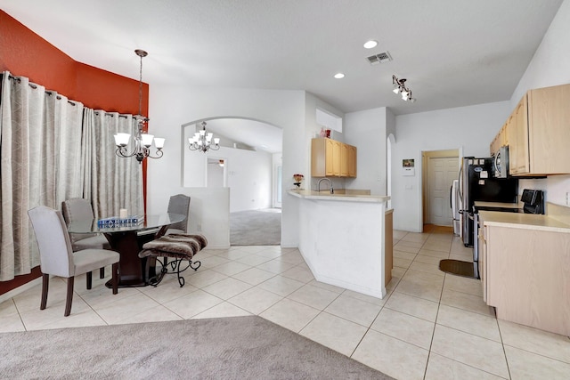 kitchen with an inviting chandelier, sink, kitchen peninsula, light brown cabinets, and light carpet