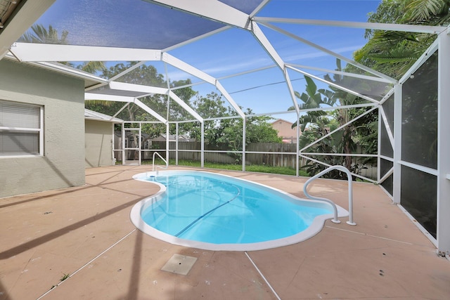 view of swimming pool featuring a patio and glass enclosure