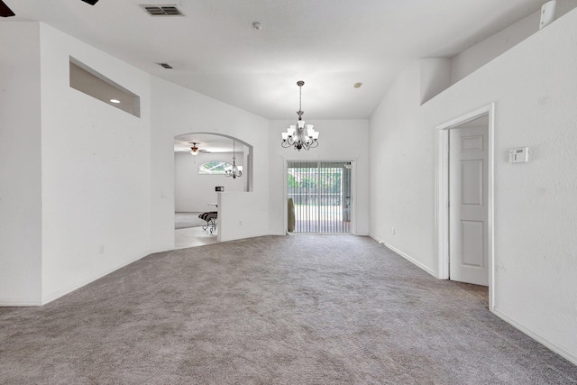 spare room featuring carpet flooring and ceiling fan with notable chandelier