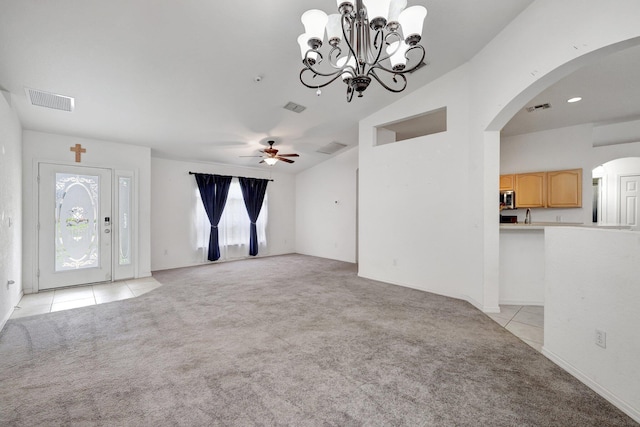 unfurnished living room featuring sink, ceiling fan with notable chandelier, lofted ceiling, and light colored carpet