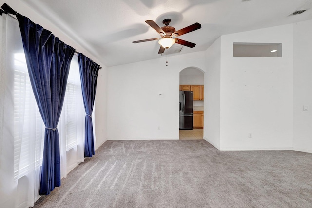 carpeted spare room with vaulted ceiling and ceiling fan