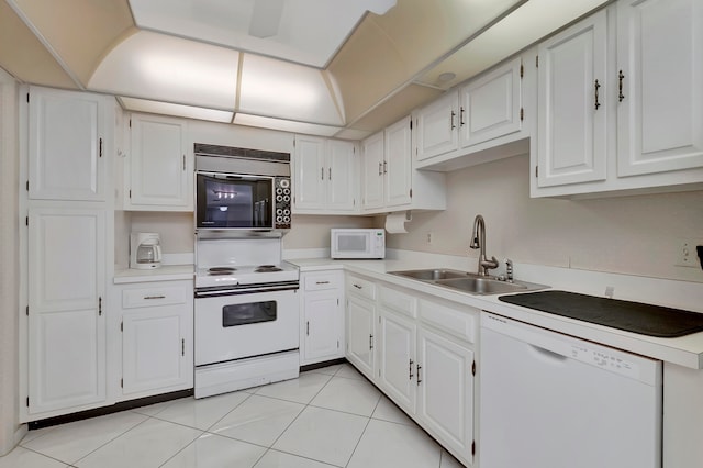 kitchen with light tile flooring, sink, white cabinets, and white appliances